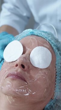 Cosmetology treatment - the doctor puts protection on the patient's eyes before the procedure