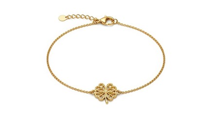 Fototapeta premium Golden four-leaf clover charm bracelet, delicate thin chain, shiny gold jewelry