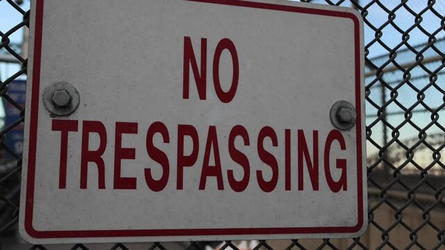 no trespassing sign on bridge infrastructure fence transportation danger private property red warning not to trespass sunset new york city queens prohibited no entry keep out away from high voltage
