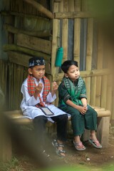 Portrait of a Muslim boy sitting with his hands in prayer position