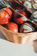 Wicker Basket with Naturally Dyed Easter Eggs and Pussy Willow Branches in Sunlight