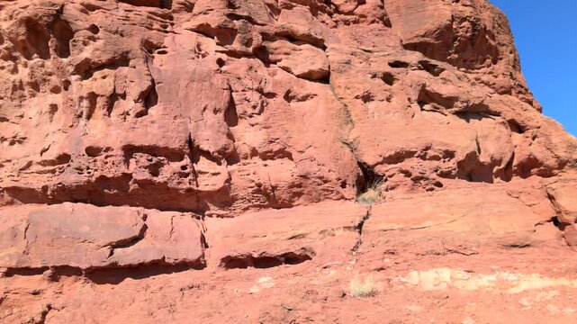 Panoramic slow motion video of vibrant read sandstone boulder of rugged surface at sugarloaf dome on bright sunny day