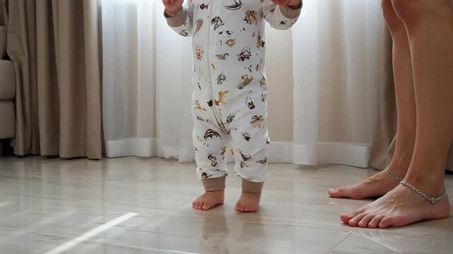 Baby taking first steps with adult