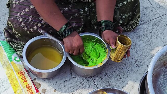 Hot, cooked wheat dough is filled in a chakli press, manually pressed into spirals/noodles onto a greased plastic sheet, sun-dried for 2-3 days until crispy, then fried for festivals.