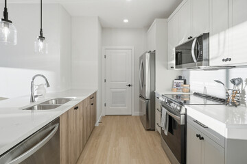 Kitchen with a stainless steel sink, a silver dishwasher, and a black stove