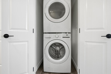 White washing machine is in a small space between two doors