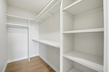 White closet with shelves and a wooden floor