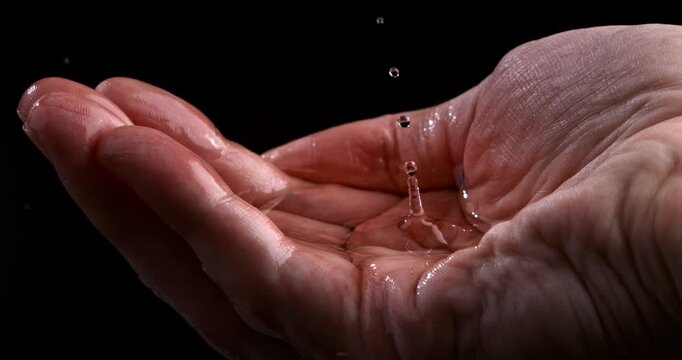  Slow Motion Clear Water Droplets Falling Into Open Human Hands On Black Background