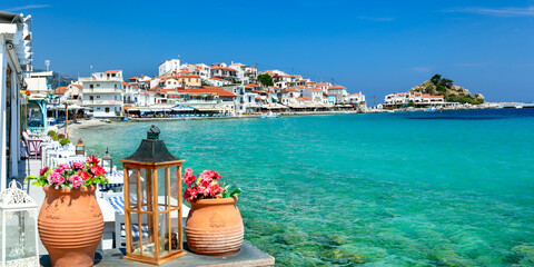 Close up of Traditional Greek Tavern Table with Ceramic Pots and Flowers by Turquoise Sea in Kokkari Village Samos Island Authentic Mediterranean Aesthetic Greece No People