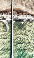 Fototapeta premium Overhead aerial view of city pier along the ocean on a beautiful day