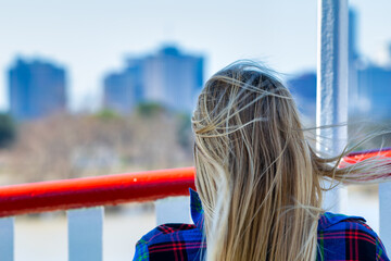 Obraz premium Rear view of blonde female enjoying New Orleans urban skyline panorama