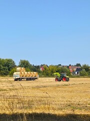 Obraz premium Harvesting: tractor with trailer full of hay