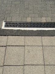 A drain on a sidewalk