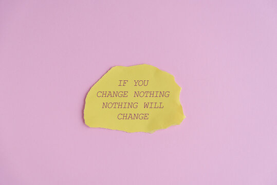 A yellow note with the text 'If you change nothing, nothing will change' on a pink background. The note is irregularly shaped and slightly crumpled.