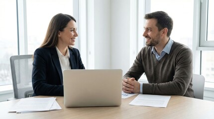 Obraz premium Female banker meets client in modern office to discuss financial plans with documents and laptop present