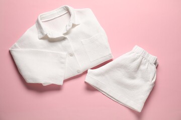 Fototapeta premium Trendy white pajamas on pink background, flat lay