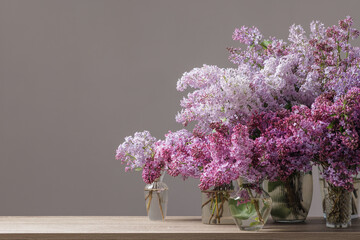 Lilac flower arrangements in glass vases on table spring decor