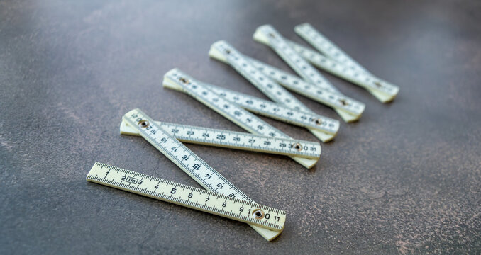 Folding measuring ruler on a gray background.The folding meter is white.Measure the size.