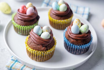 Chocolate banana cupcakes with chocolate cream topping with easter eggs for Easter holidays