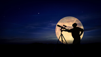 Amateur astronomer using telescope for watching stars, Moon, planets and other celestial objects from a field in nature. © astrosystem