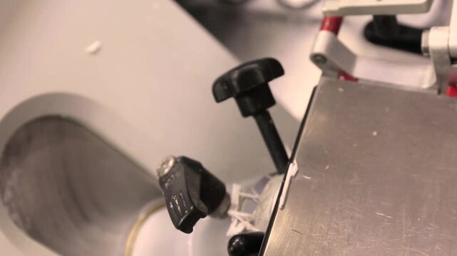 Close up of a medical microtome producing ultra thin tissue slices Prepared tissue placed on glass slide for histology analysis Demonstrates laboratory process and precise sample preparation