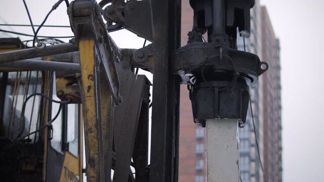 Pile driving rig clamping concrete pile during foundation installation