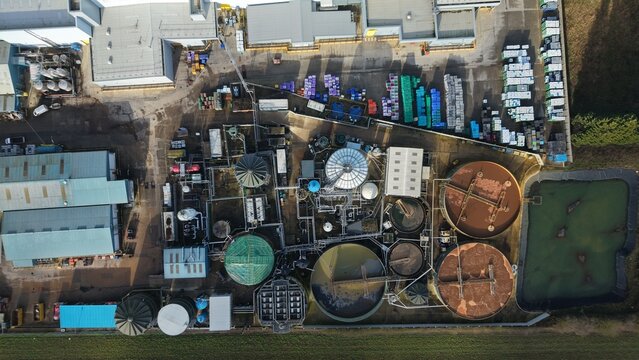 Aerial view of industrial complex with tanks and buildings casting long shadows, a symphony of textures and tones, Princes Factory, Sutton Bridge, United Kingdom.