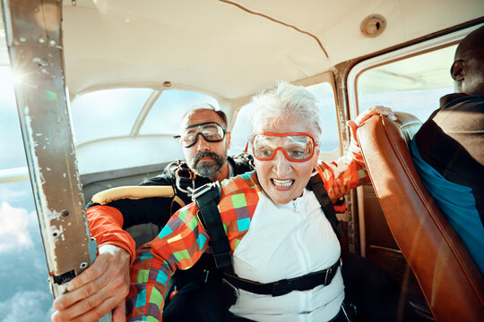 Senior woman preparing for tandem skydive in small airplane
