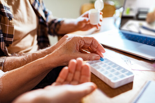 Seniors managing medication with pill organizer at home