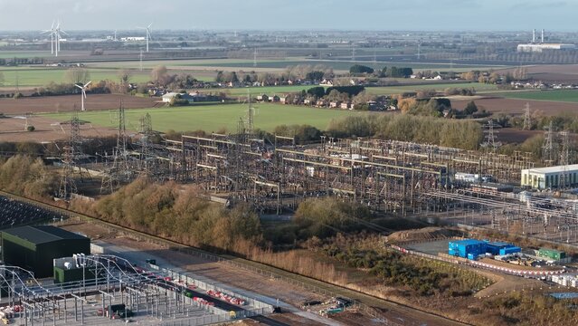 Aerial view of the National Grid Walpole Substation where steel towers and power lines converge amid the rural landscape, Wisbech, United Kingdom.