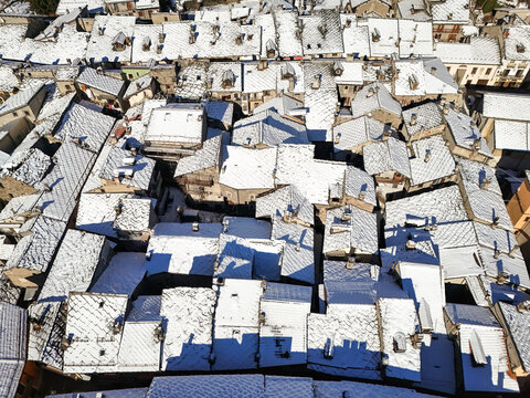 Aerial view of roofs dusted with snow creating a monochromatic mosaic, Exilles, Piemonte, Italy.