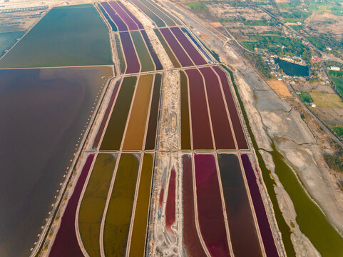 Aerial view of a mesmerizing mosaic of colorful salt pans creating a stunning geometric pattern against the arid landscape, Sambhar, Rajasthan, India.
