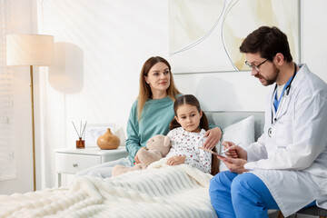 Obraz premium Doctor visiting little girl and her mother at home