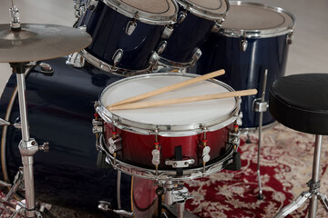 Fototapeta premium Modern drum kit with drumsticks in studio, closeup