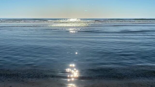 Meditative 4K video of sunlight shimmering on gentle blue ocean ripples. Serene atmosphere with natural sea sounds and a clear horizon. Perfect for Zen, mindfulness, and relaxation backgrounds.