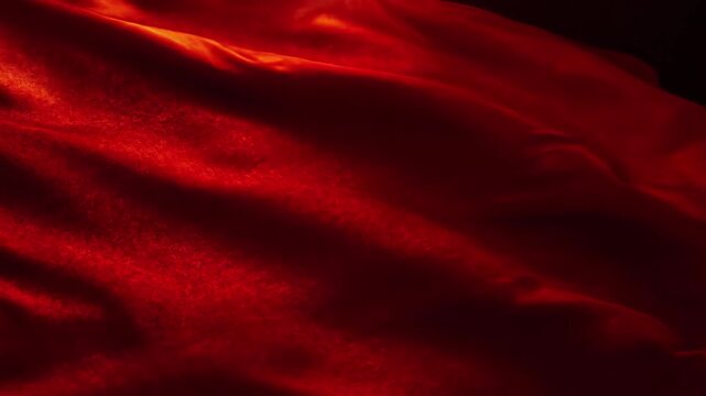 Abstract closeup of rich, flowing, deep red fabric texture with dramatic lighting and shadows