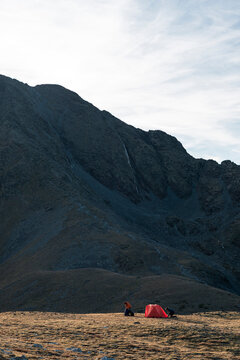 Epic alpine backdrop emphasizing human scale during campsite setup