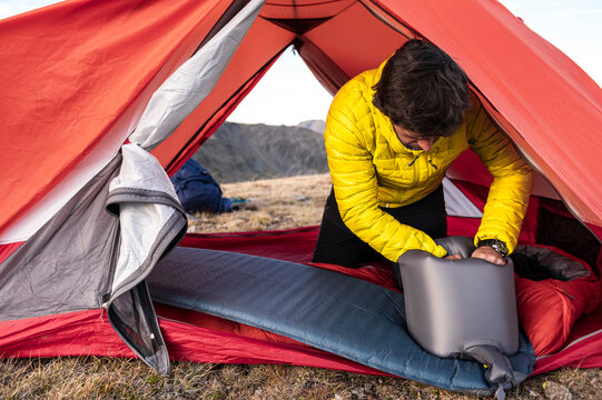 Experienced hiker adjusting inflated pad for overnight rest