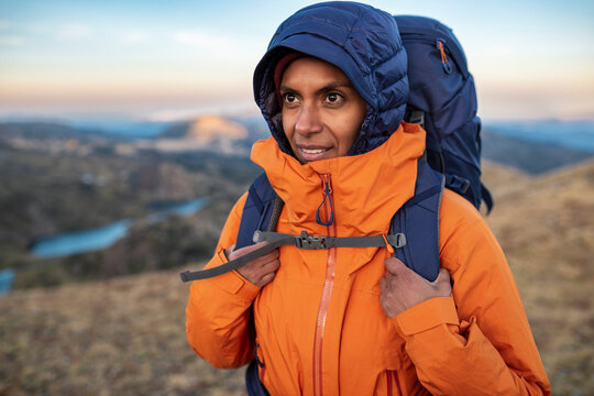 Close-up of hiker wearing technical jacket and backpack in alpine setting