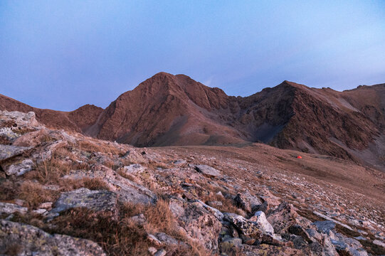 Remote mountain camp highlighting human fragility within wild landscape