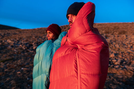 Focused hikers enduring cold morning while watching mountain sunrise