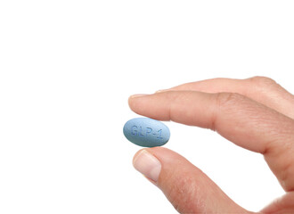 A hand holding a GLP1 pill isolated on white background