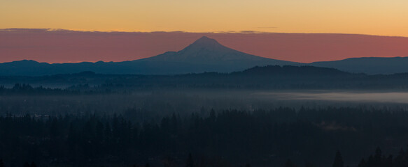 The scenic Mount Hood rises from the forested landscape of northern Oregon. This iconic Pacific Northwest mountain is part of the Cascade Mountain Range.