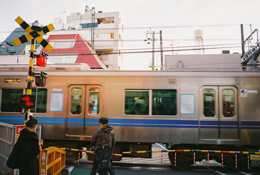 Train crossing with incidental people waiting for the subway to pass 