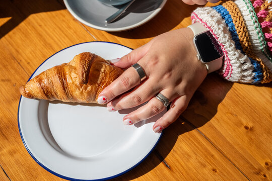 Taking croissant from plate