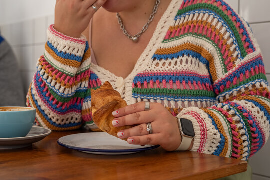 Woman eating croissant 