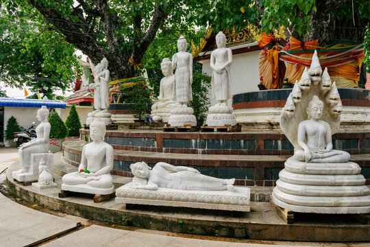 Buddha statues in various attitudes in a temple courtyard in Thailand