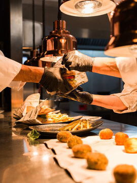 Chefs preparing gourmet burger together 