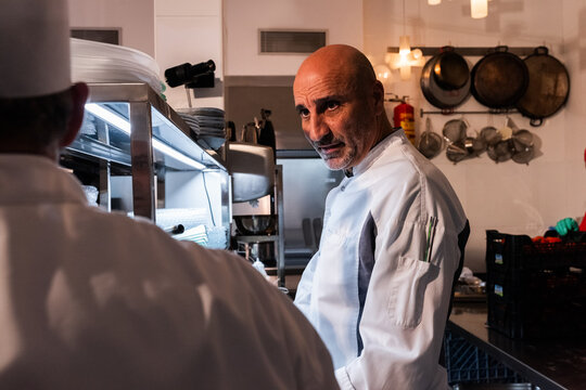 Chef Overseeing Kitchen Activity During Busy Dinner Service