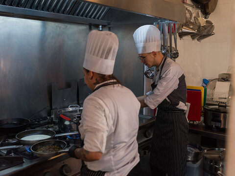 Chefs cooking on gas stove in restaurant kitchen 